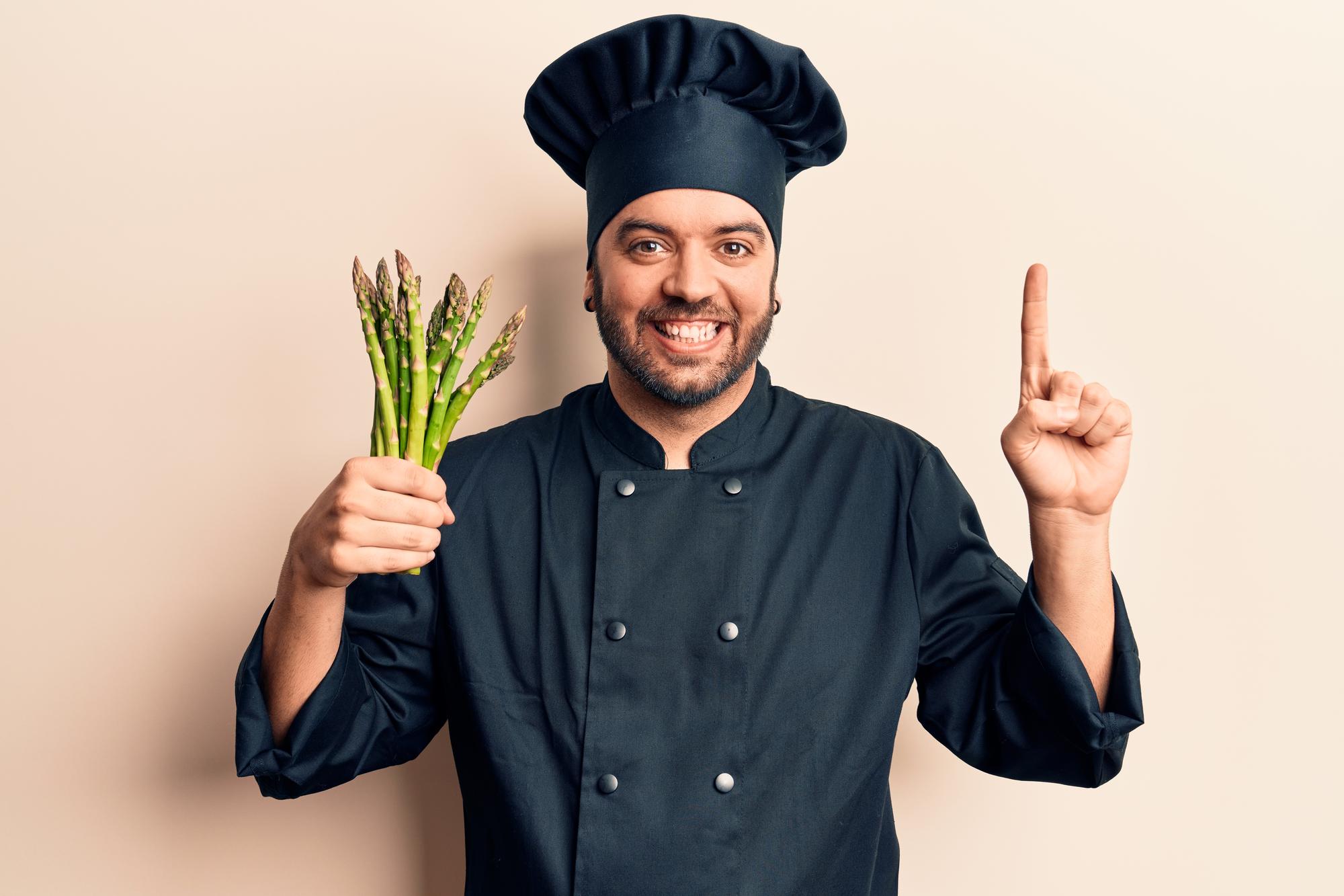 Portrait of smiling chef holding herbs